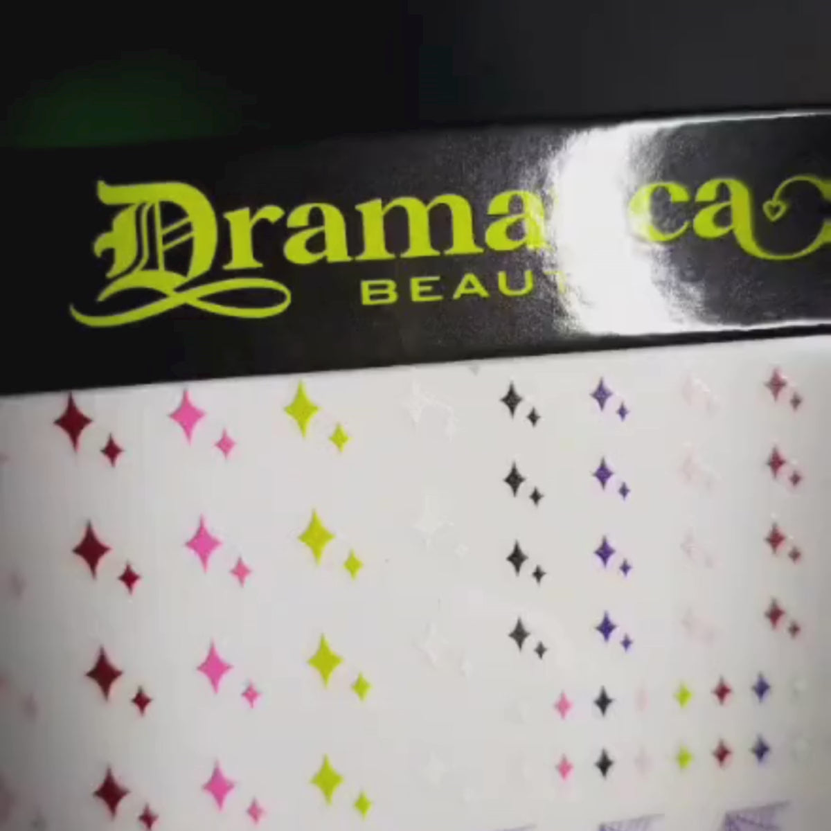 Video of Dramatica Beauty's Nail sticker sheet. Featuring pink, green, purple, red, white and black original illustrations. These include spiderwebs, starbursts, bats, hearts, and stars. 